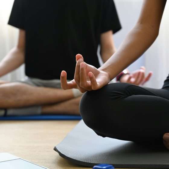 Image shows two people practicing yoga in a studio.
